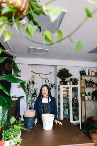 Female florist working in contemporary greenshop  photo