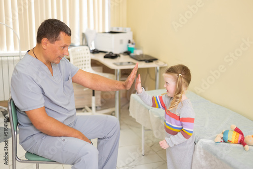 Doctor dad high five his little patient in hospital
