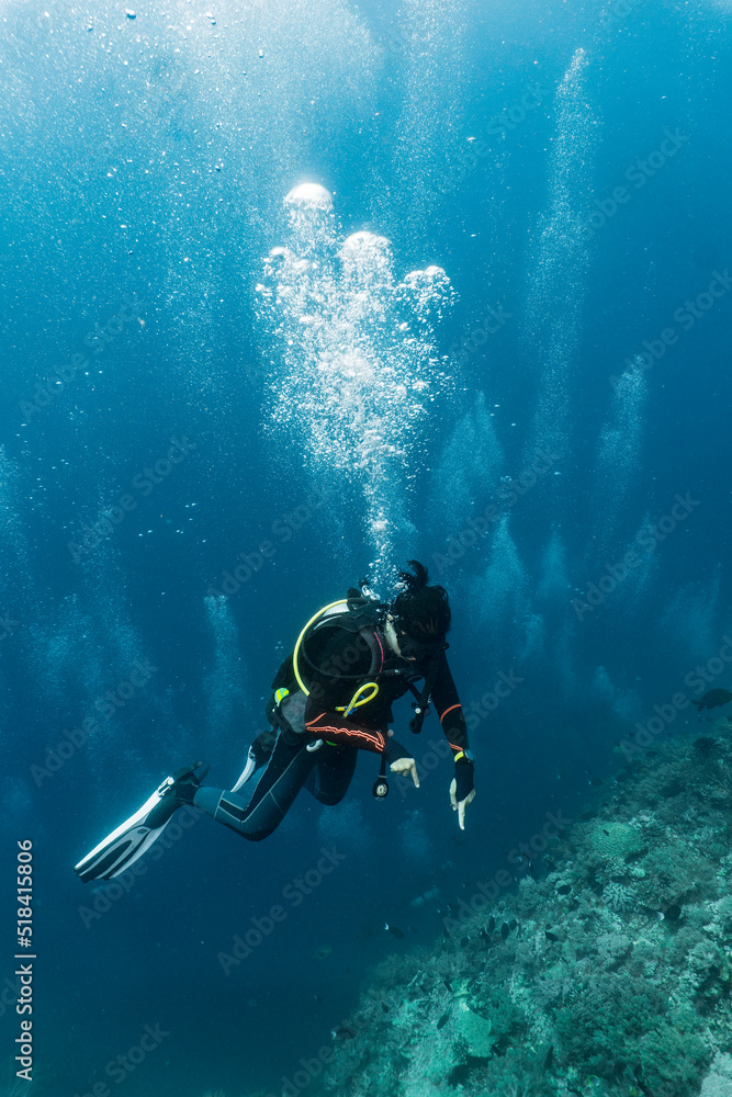Woman ascending into the clear water at the Tubbataha Reef Woman ascending into the clear water at the Tubbataha Reef