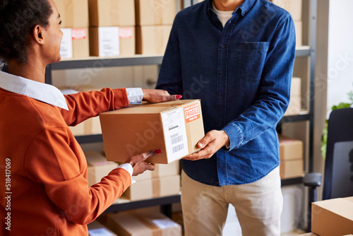 Woman giving parcel to man in delivery office photo