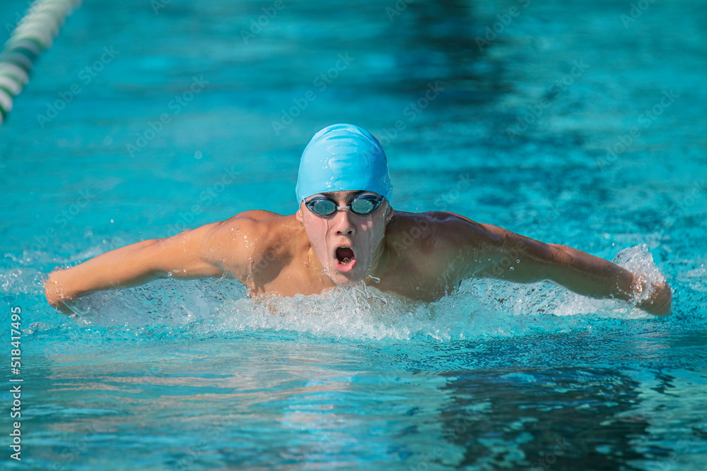 Teen races in butterfly swimming event