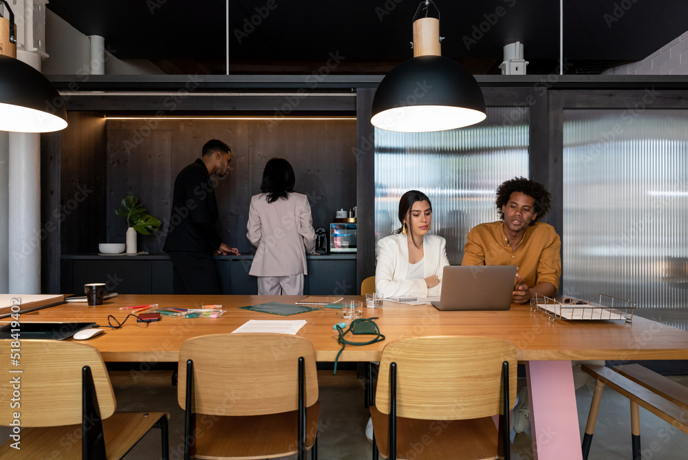 Diverse coworkers speaking in workplace Diverse coworkers speaking in workplace