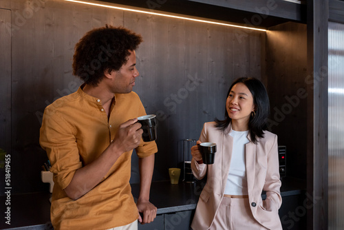 Cheerful diverse coworkers having coffee break photo