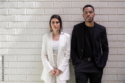 Confident male and female managers against brick wall photo