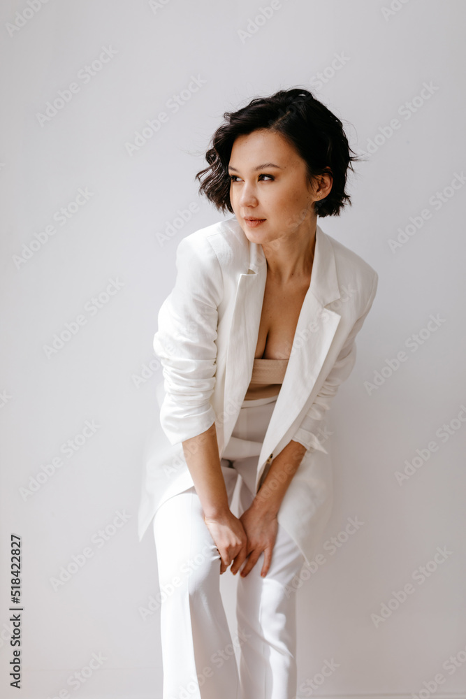 Fashionable woman in suit standing near wall Fashionable woman in suit standing near wall