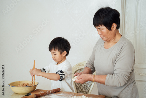 Cute boy cooking with grandma photo