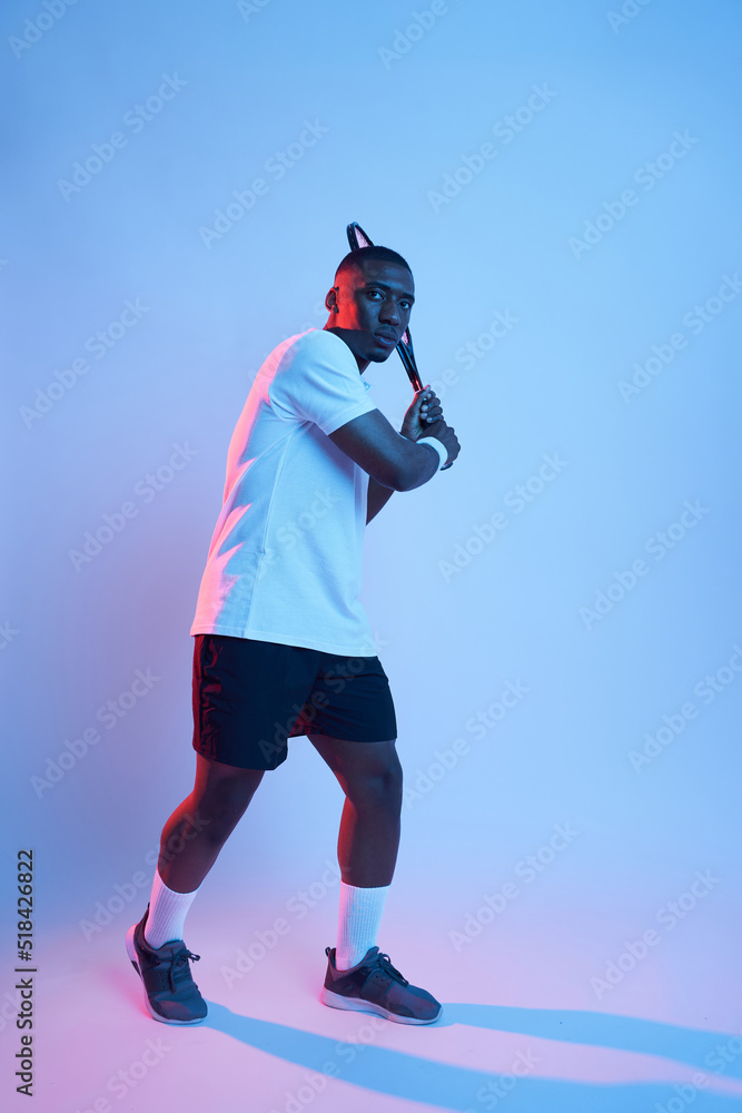 Male tennis player swinging racket