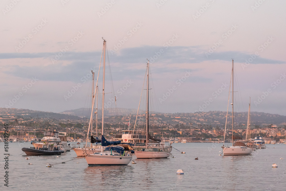 Yachts on the dock in the port against the backdrop of sunset on the ocean. California. Newport Beach
