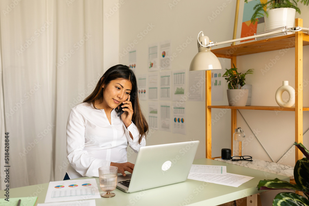 Mixed race business woman calling by phone at office Mixed race business woman calling by phone at office