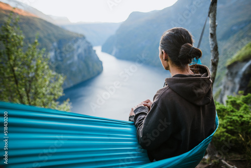 Man resting in hammock and watching Norwegian landscape