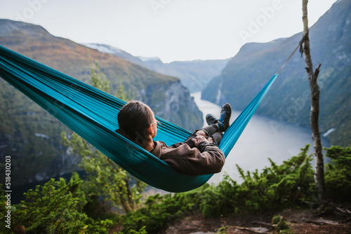 Man resting in hammock above Geirangerfjord in Norway photo