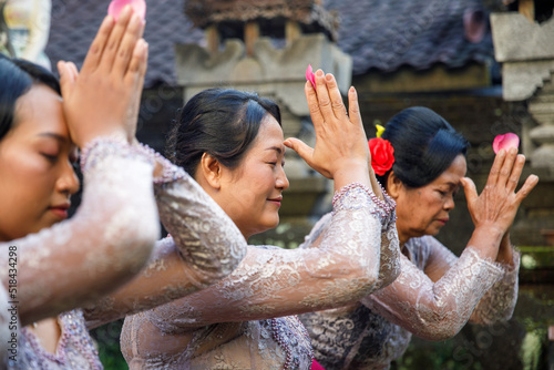 Balinese family praying together wearing traditional clothes