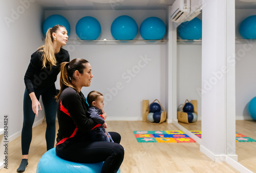 Mother and baby attending a postpartum recovery class photo