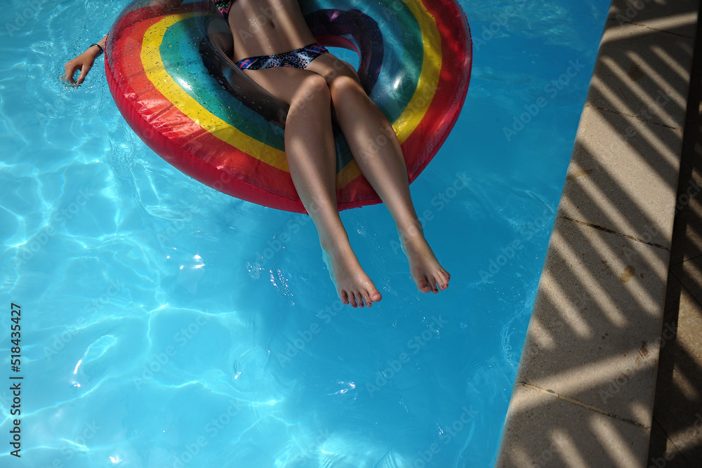 Tween Floating Inpool A teenage girl plays in a swimming pool with a rainbow pool float Stock ...