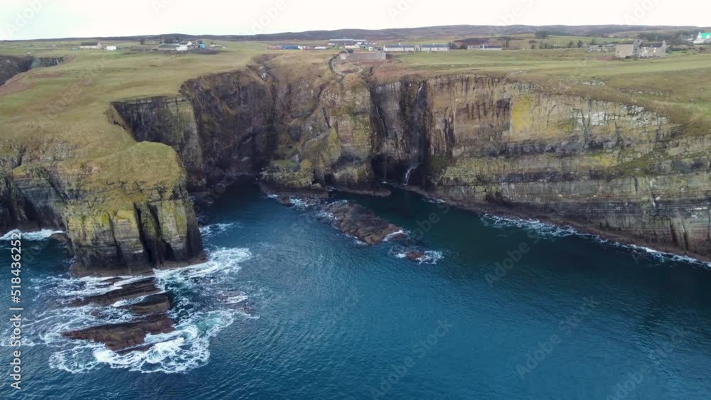 Drone shot of the cliffs and waterfall at Whaligoe in Scotland UK