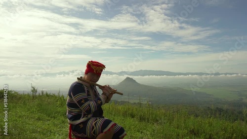 Indigenous person playing flute on a mountain photo