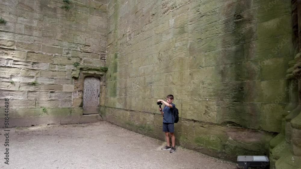 Young blogger boy. Creative kids. Kid using camera and gimble. A young boy in a filming position about travel Young blogger boy. Creative kids. Kid using camera and gimble. A young boy in a filming position about travel
