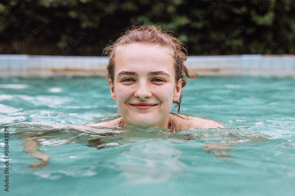 Happy woman playing in the pool during the summer vacations Happy woman playing in the pool during the summer vacations