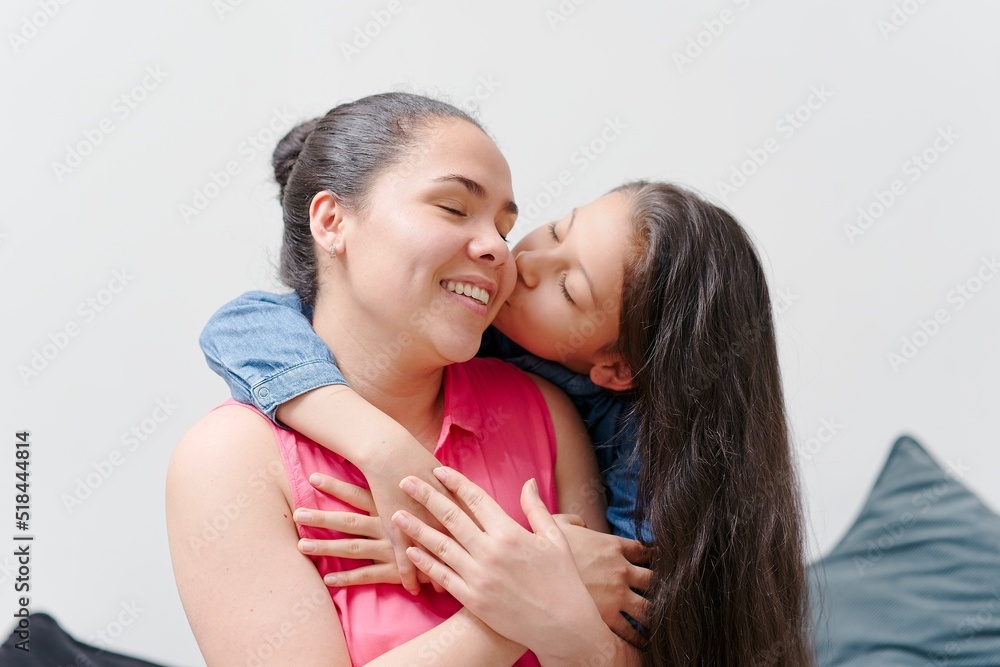 little girl hugging, kissing and smiling with her mother, young woman with her daughter little girl hugging, kissing and smiling with her mother, young woman with her daughter
