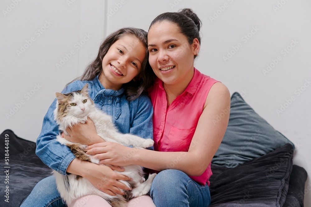 mother and daughter playing with their pet cat