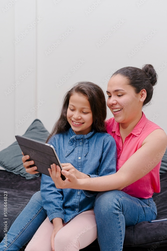 mother and daughter looking at tablet, watching movies or social networks mother and daughter looking at tablet, watching movies or social networks