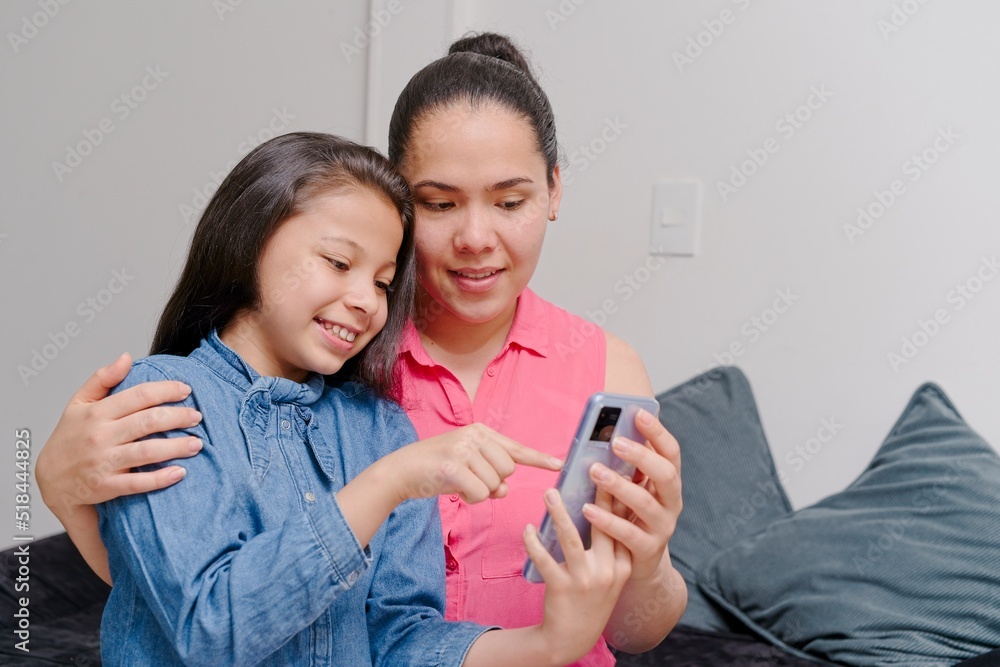 mother and daughter looking at a mobile phone mother and daughter looking at a mobile phone