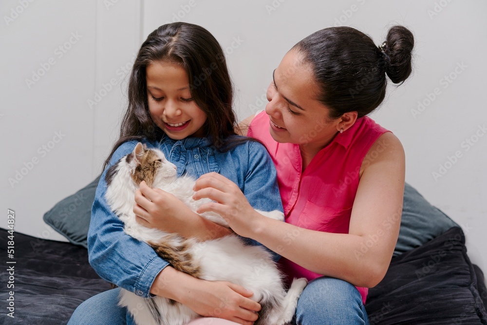 mother and daughter playing with their pet cat