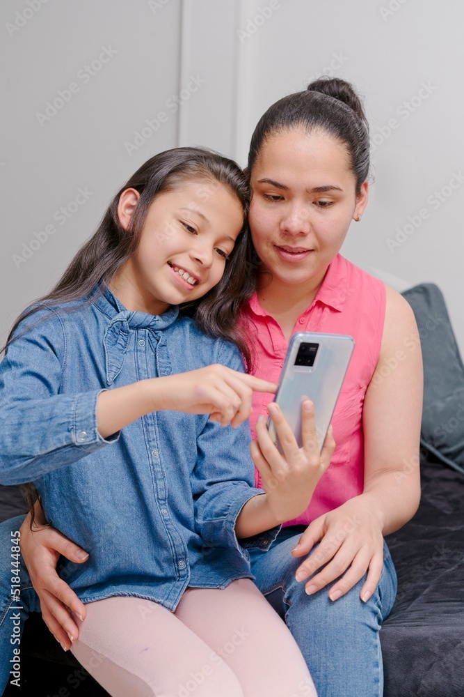 mother and daughter looking at a mobile phone mother and daughter looking at a mobile phone