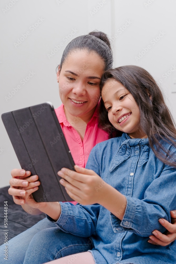 mother and daughter looking at tablet, watching movies or social networks mother and daughter looking at tablet, watching movies or social networks