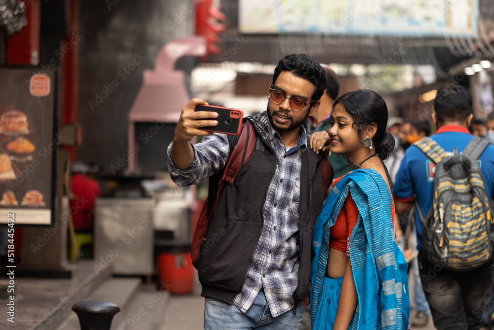 Indian couple taking selfie and enjoying at outdoors in daytime Indian couple taking selfie and enjoying at outdoors in daytime
