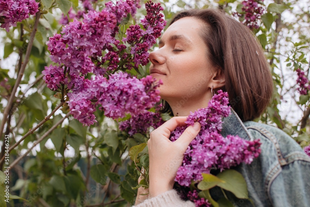 Brunette woman smelling lilacs - profile portrait Brunette woman smelling lilacs - profile portrait