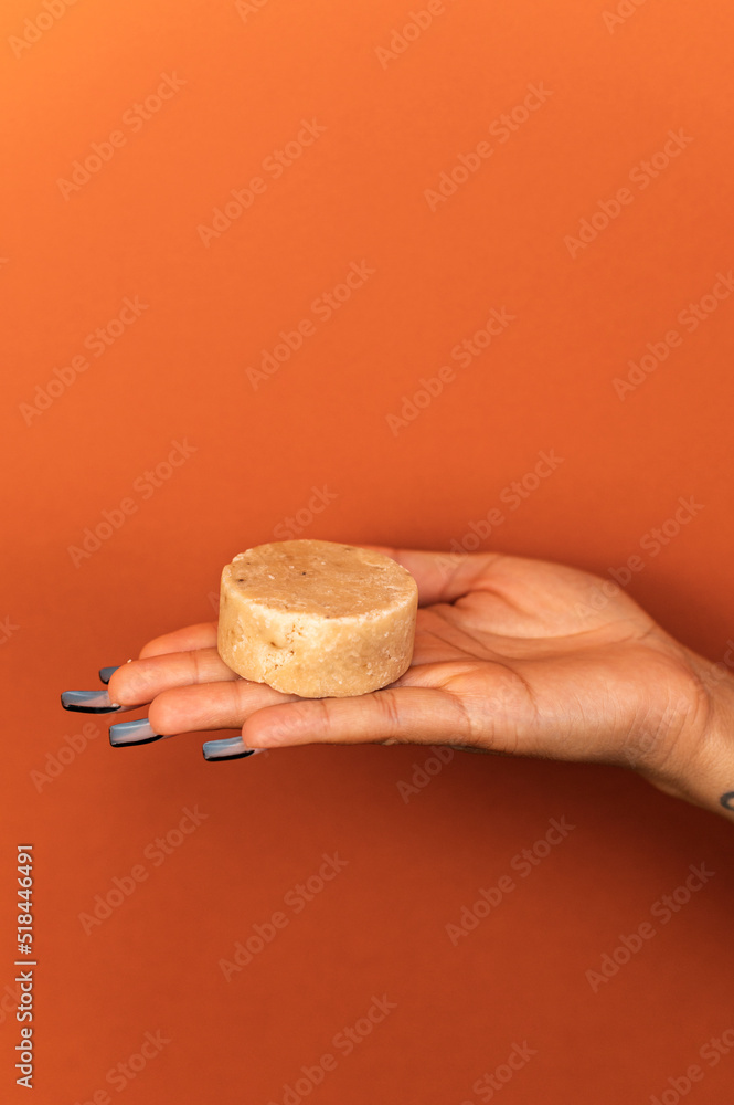 Brown skinned woman holding handmade soap