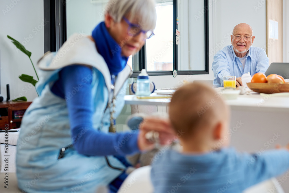 Grandfather watching baby eating. Grandfather watching baby eating.