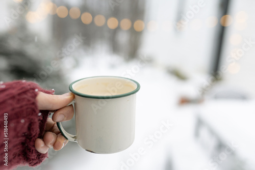 hand holding a coffee cup in snow  photo