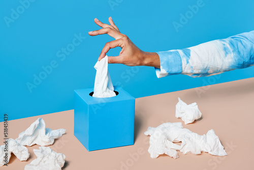 Crop woman taking tissue from box