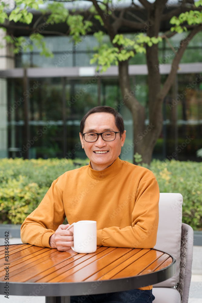 mature man enjoying coffee outdoors and looking at camera mature man enjoying coffee outdoors and looking at camera
