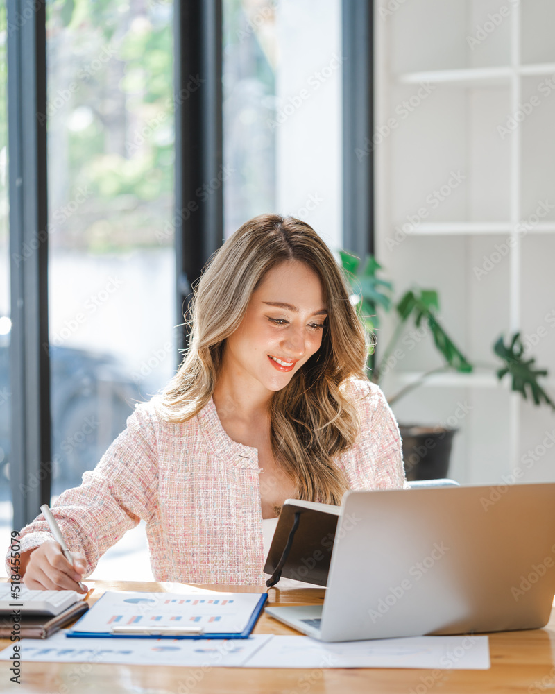 Beautiful young Asian business woman working at office workplace, using laptop computer, sitting at desk and smile. Beautiful young Asian business woman working at office workplace, using laptop computer, sitting at desk and smile.