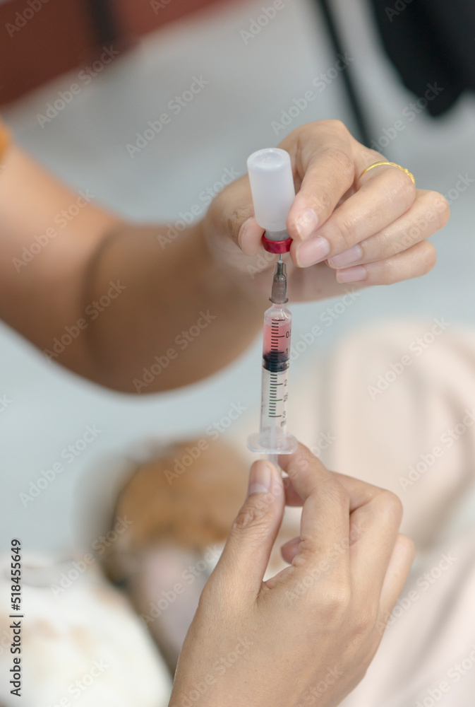 hand draws solution into syringe from vial in clinic office hand draws solution into syringe from vial in clinic office