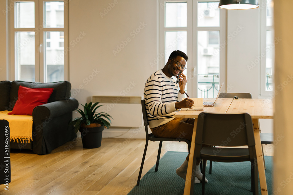 Smiling man at work having a phone call