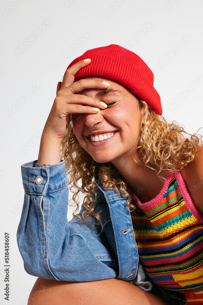 Smiling trendy girl sitting in white studio Smiling trendy girl sitting in white studio