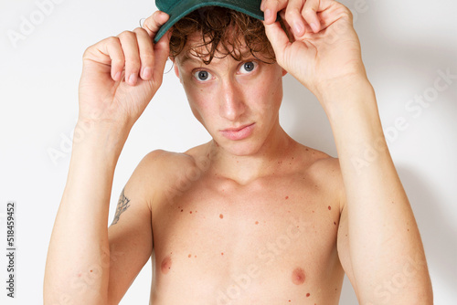 Young shirtless man with green cap on his head photo
