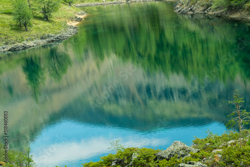 Reflection of forest and mountain range in mountain lake