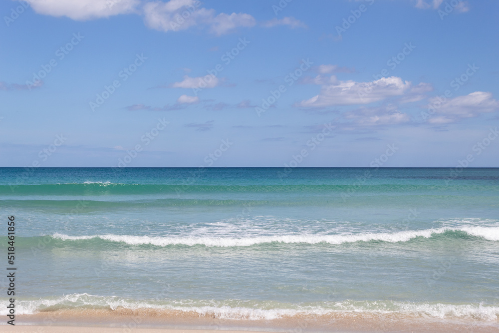 Background of a beach horizon with clouds, the sea with small waves and a bit of sand on the shore