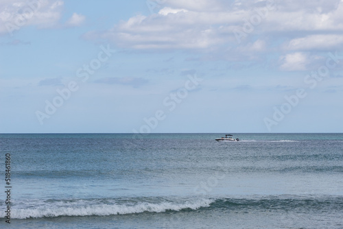 A small boat sailing on a calm sea during a sunny day