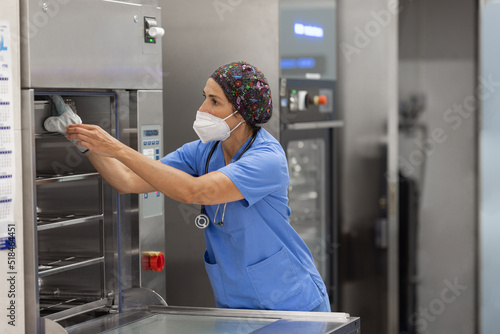nurse with facemask, working with  Washer Disinfector Machine. photo