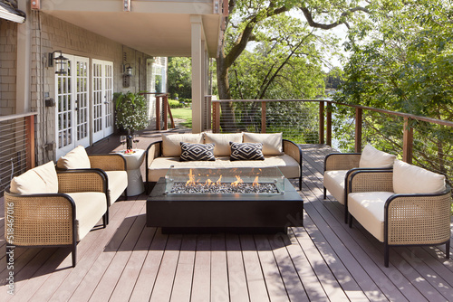 Outdoor furniture sitting area and fireplace on backyard deck of home photo