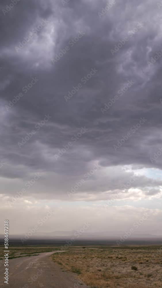 Timelapse of dark storm clouds moving over desert landscape looking down dirt road in Utah. Timelapse of dark storm clouds moving over desert landscape looking down dirt road in Utah.