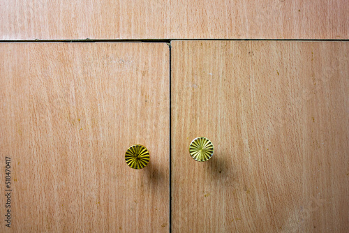 Old uneven cabinet doors with handles. Broken, dilapidated crooked furniture cabinet with handles close-up background.