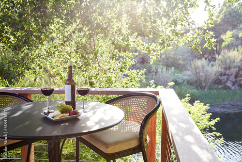 Cheese plate with wine on table on outdoor backyard deck photo