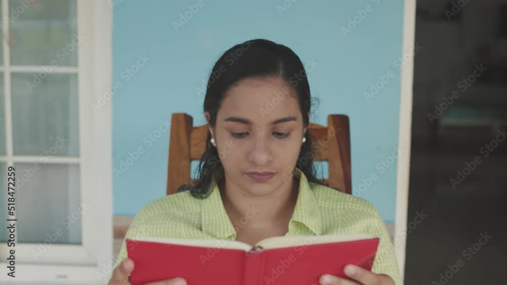 latin woman sitting in rocking chair, reading book, closeup latin woman sitting in rocking chair, reading book, closeup
